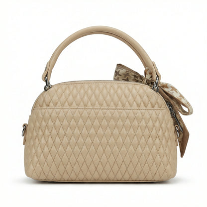 Dune — A quilted top-handle bag with a tied scarf detail.