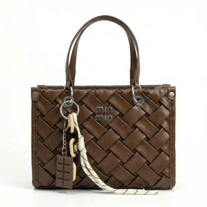 Slate — A top-handle bag with a quilted texture and metal details.