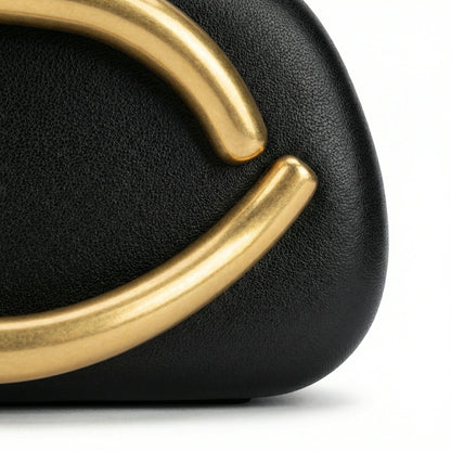 Moonstone — A compact clutch with a rounded shape and oversized ring detail.