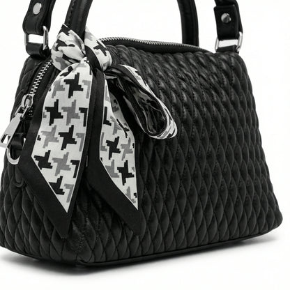 Dune — A quilted top-handle bag with a tied scarf detail.