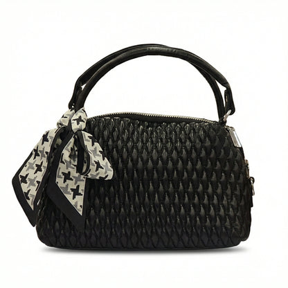 Dune — A quilted top-handle bag with a tied scarf detail.