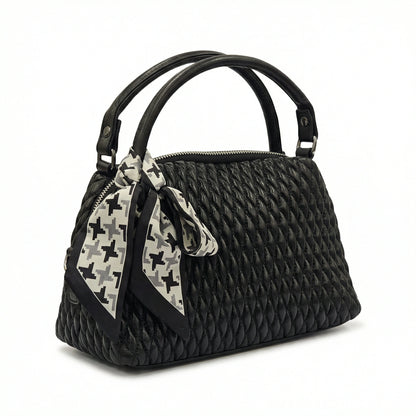 Dune — A quilted top-handle bag with a tied scarf detail.