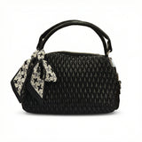 Dune — A quilted top-handle bag with a tied scarf detail.