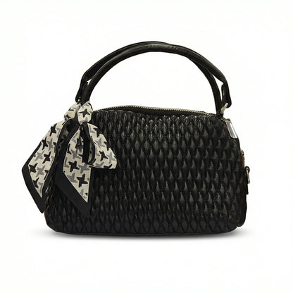 Dune — A quilted top-handle bag with a tied scarf detail.