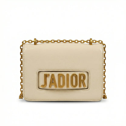Quartz — A compact flap-style crossbody bag with a chain strap and metal accent.