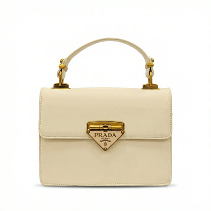 Pearl — A structured top-handle bag with a flap and front metal detail.