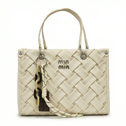 Slate — A top-handle bag with a quilted texture and metal details.