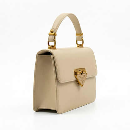 Pearl — A structured top-handle bag with a flap and front metal detail.