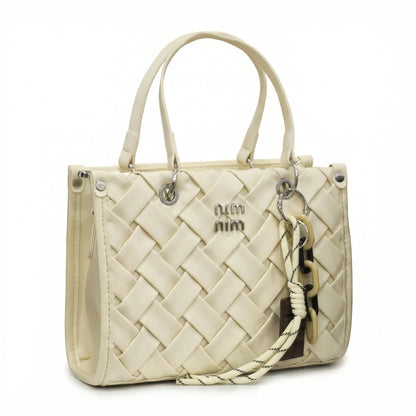 Slate — A top-handle bag with a quilted texture and metal details.