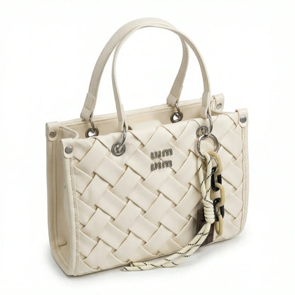 Slate — A top-handle bag with a quilted texture and metal details.