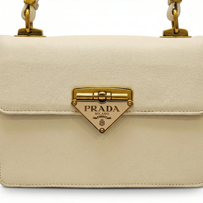 Pearl — A structured top-handle bag with a flap and front metal detail.