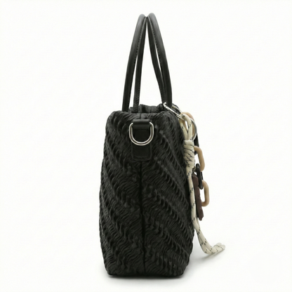 Mousse — A top-handle bag with a gathered-look finish and chain accent.