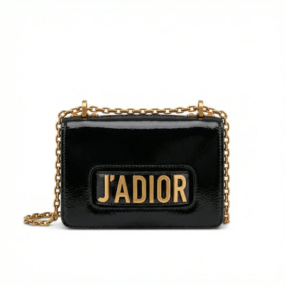 Quartz — A compact flap-style crossbody bag with a chain strap and metal accent.