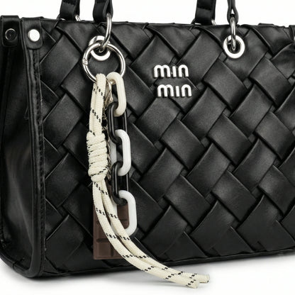 Slate — A top-handle bag with a quilted texture and metal details.