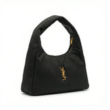 Eclipse — A curved shoulder bag with a textured finish and small metal detail.