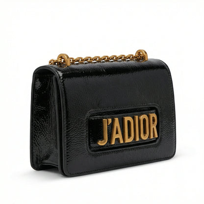 Quartz — A compact flap-style crossbody bag with a chain strap and metal accent.