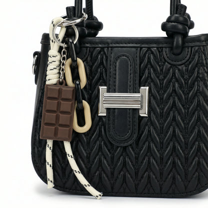Basalt — A compact crossbody bag with a top handle and wide webbing strap.