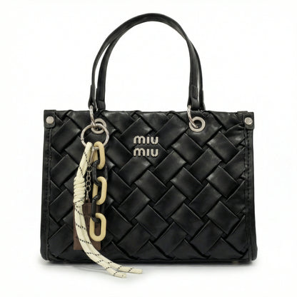 Slate — A top-handle bag with a quilted texture and metal details.