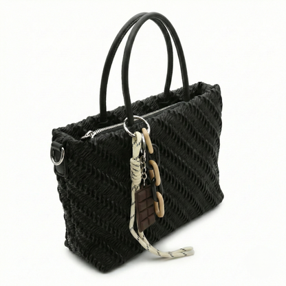 Mousse — A top-handle bag with a gathered-look finish and chain accent.