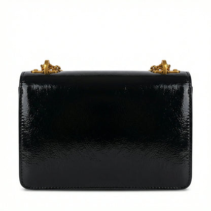 Quartz — A compact flap-style crossbody bag with a chain strap and metal accent.