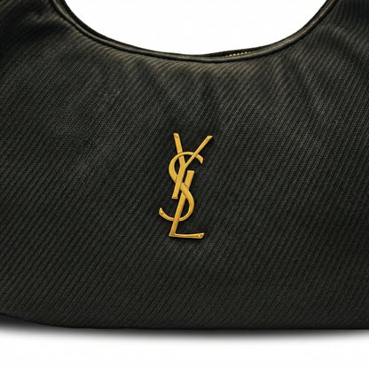 Eclipse — A curved shoulder bag with a textured finish and small metal detail.