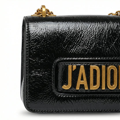 Quartz — A compact flap-style crossbody bag with a chain strap and metal accent.