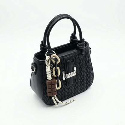Basalt — A compact crossbody bag with a top handle and wide webbing strap.