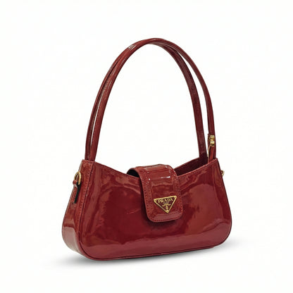 Jet — A curved shoulder bag with a smooth finish and small metal detail.