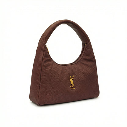 Eclipse — A curved shoulder bag with a textured finish and small metal detail.