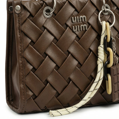Slate — A top-handle bag with a quilted texture and metal details.