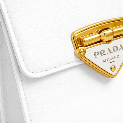 Pearl — A structured top-handle bag with a flap and front metal detail.