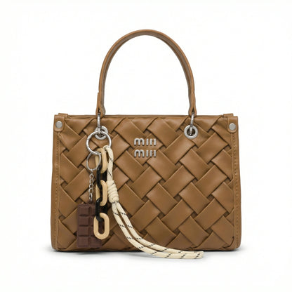Slate — A top-handle bag with a quilted texture and metal details.