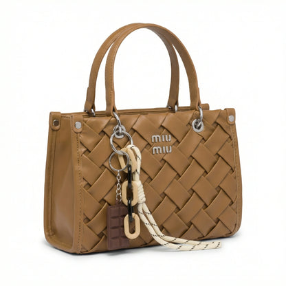 Slate — A top-handle bag with a quilted texture and metal details.