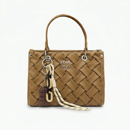 Slate — A top-handle bag with a quilted texture and metal details.