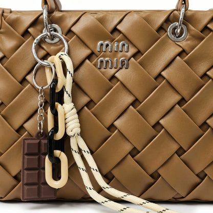 Slate — A top-handle bag with a quilted texture and metal details.