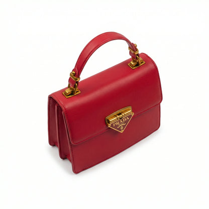 Pearl — A structured top-handle bag with a flap and front metal detail.