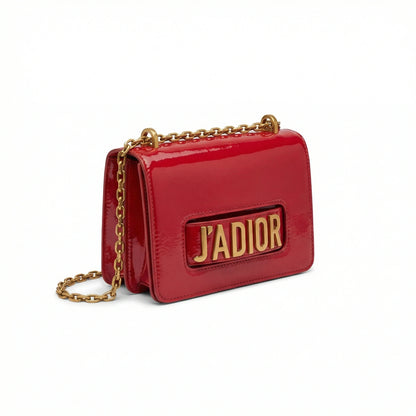 Quartz — A compact flap-style crossbody bag with a chain strap and metal accent.
