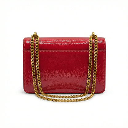 Quartz — A compact flap-style crossbody bag with a chain strap and metal accent.
