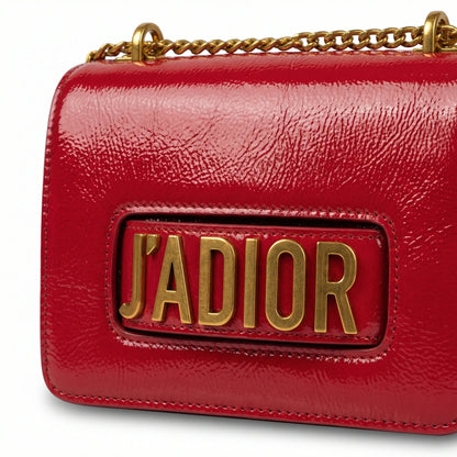 Quartz — A compact flap-style crossbody bag with a chain strap and metal accent.