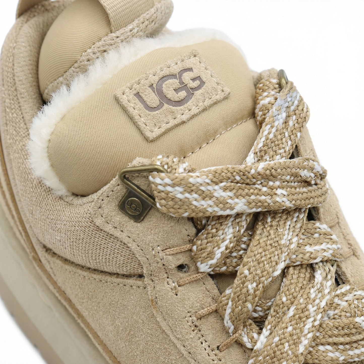 Close-up of TKN Dune Platform showing technical rope laces, metallic hardware, and plush shearling lining