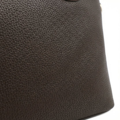 Onyx — A structured tote with knotted top handles and metal-tone details.