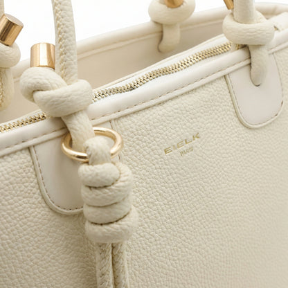 Onyx — A structured tote with knotted top handles and metal-tone details.