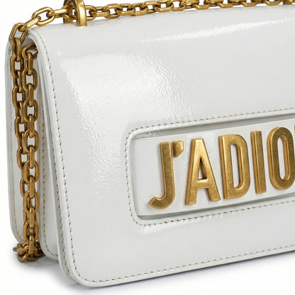 Quartz — A compact flap-style crossbody bag with a chain strap and metal accent.