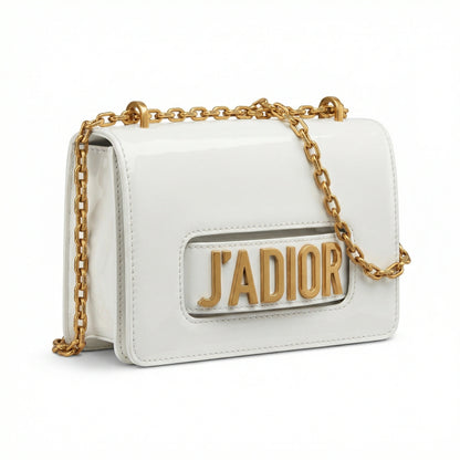 Quartz — A compact flap-style crossbody bag with a chain strap and metal accent.
