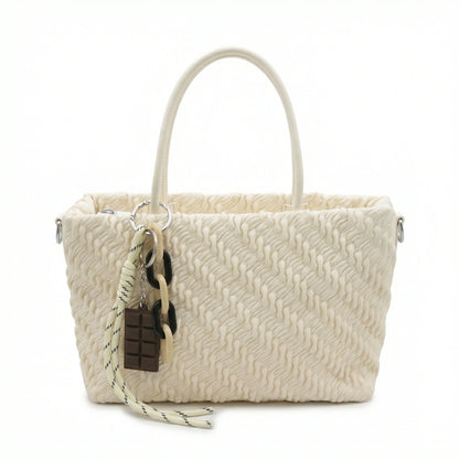 Mousse — A top-handle bag with a gathered-look finish and chain accent.